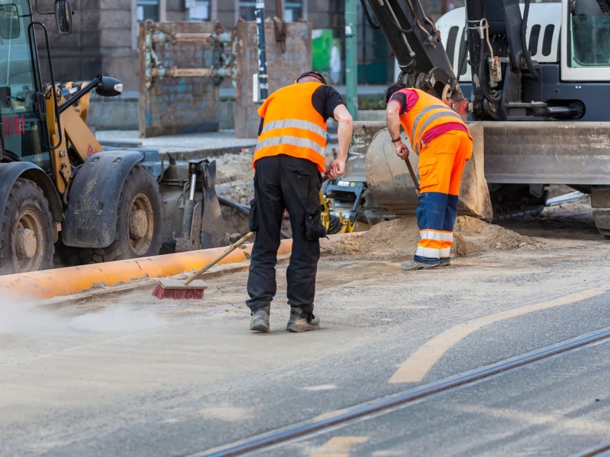Construction site cleanup service in Dallas showing workers removing debris